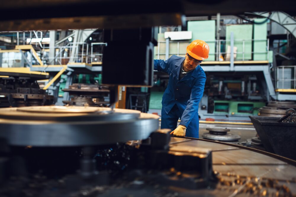 Turner stanging at the automated lathe, factory